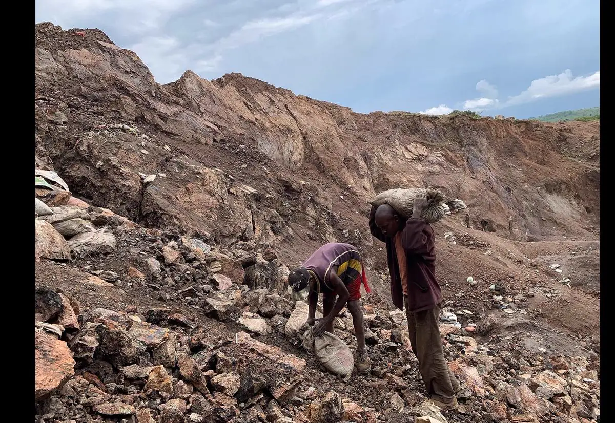 A geologist and members of a Congolese mining cooperative reviewing field survey maps